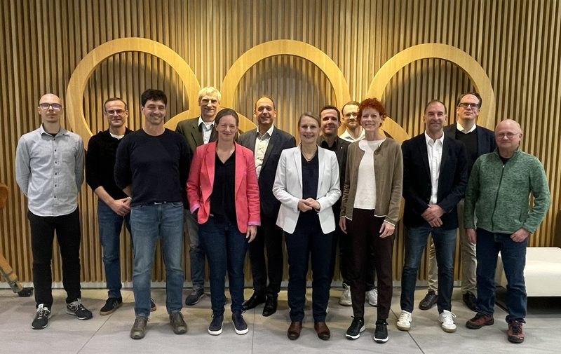 Gruppenfoto: Die Mitglieder des Projektbeirats vor den Olympischen Ringen in den Räumen des DOSB in Frankfurt am Main